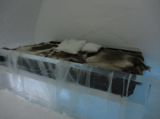 A regular room, with bed covered with reindeer skin.